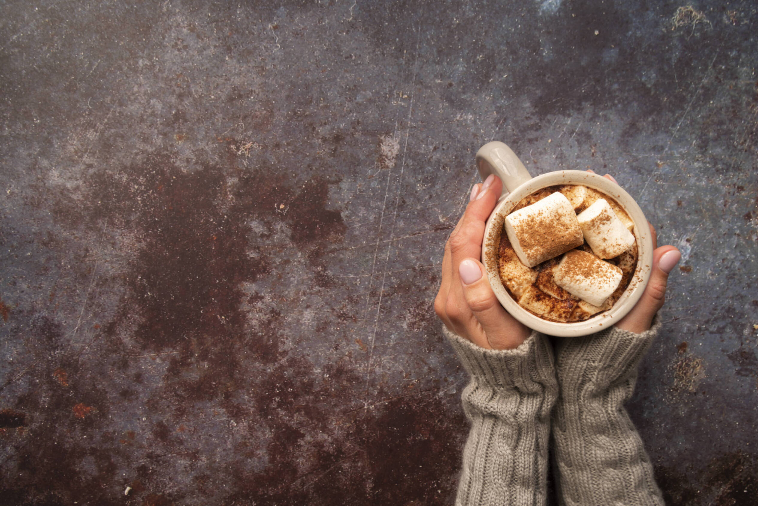 Woman clasping a cup of hot cocoa
