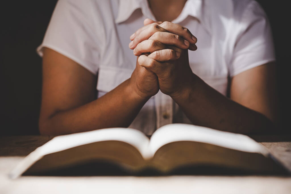Woman praying over a prayer book or Bible