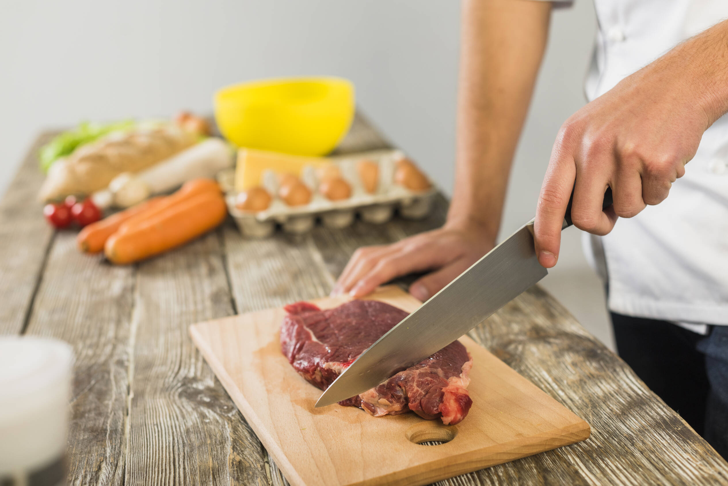 Chef cutting raw steak