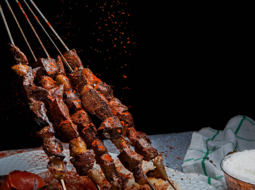 Beef shish kabobs being flavored with paprika