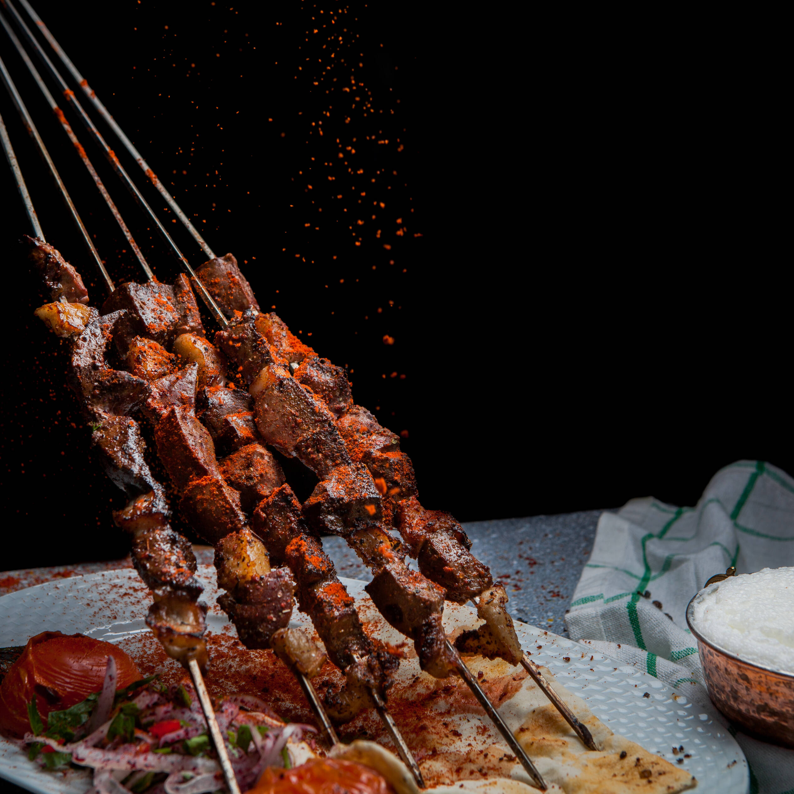Beef shish kabobs being flavored with paprika