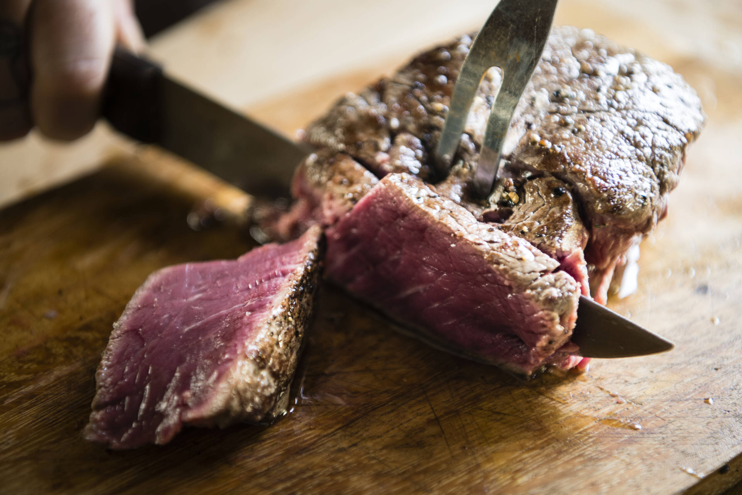Cooked sirloin steak being sliced