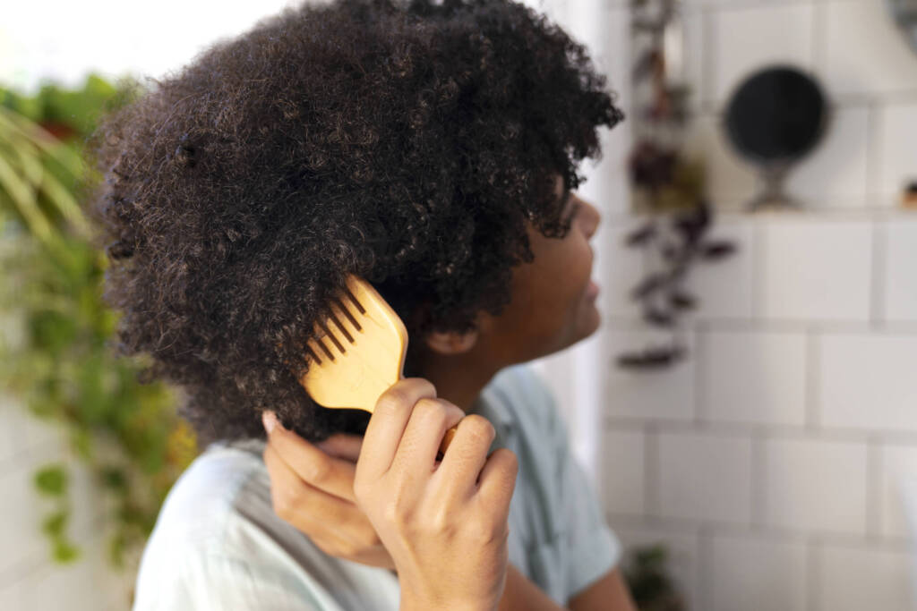 Woman combing Afro hair