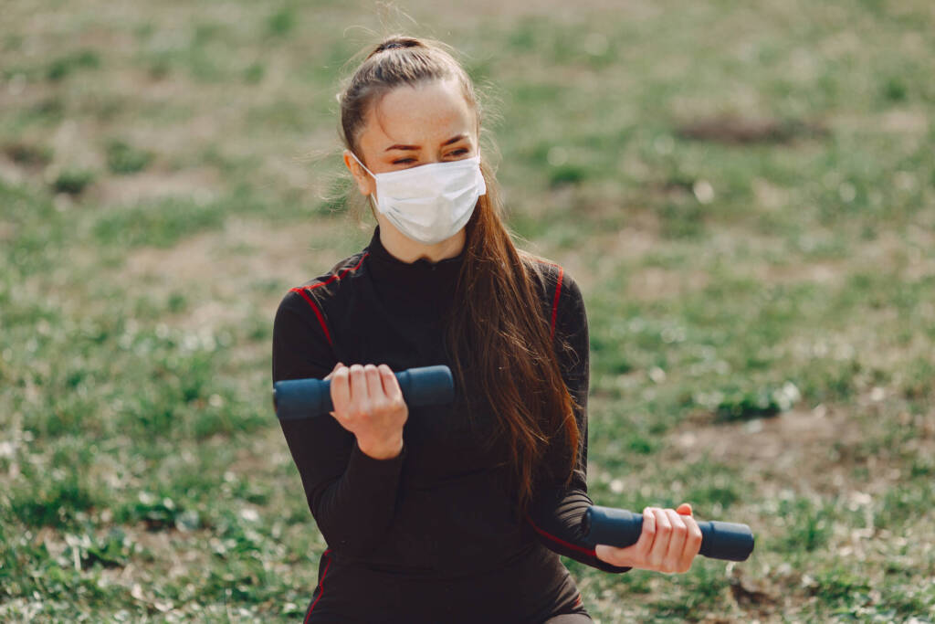 Woman exercising outdoors with weights