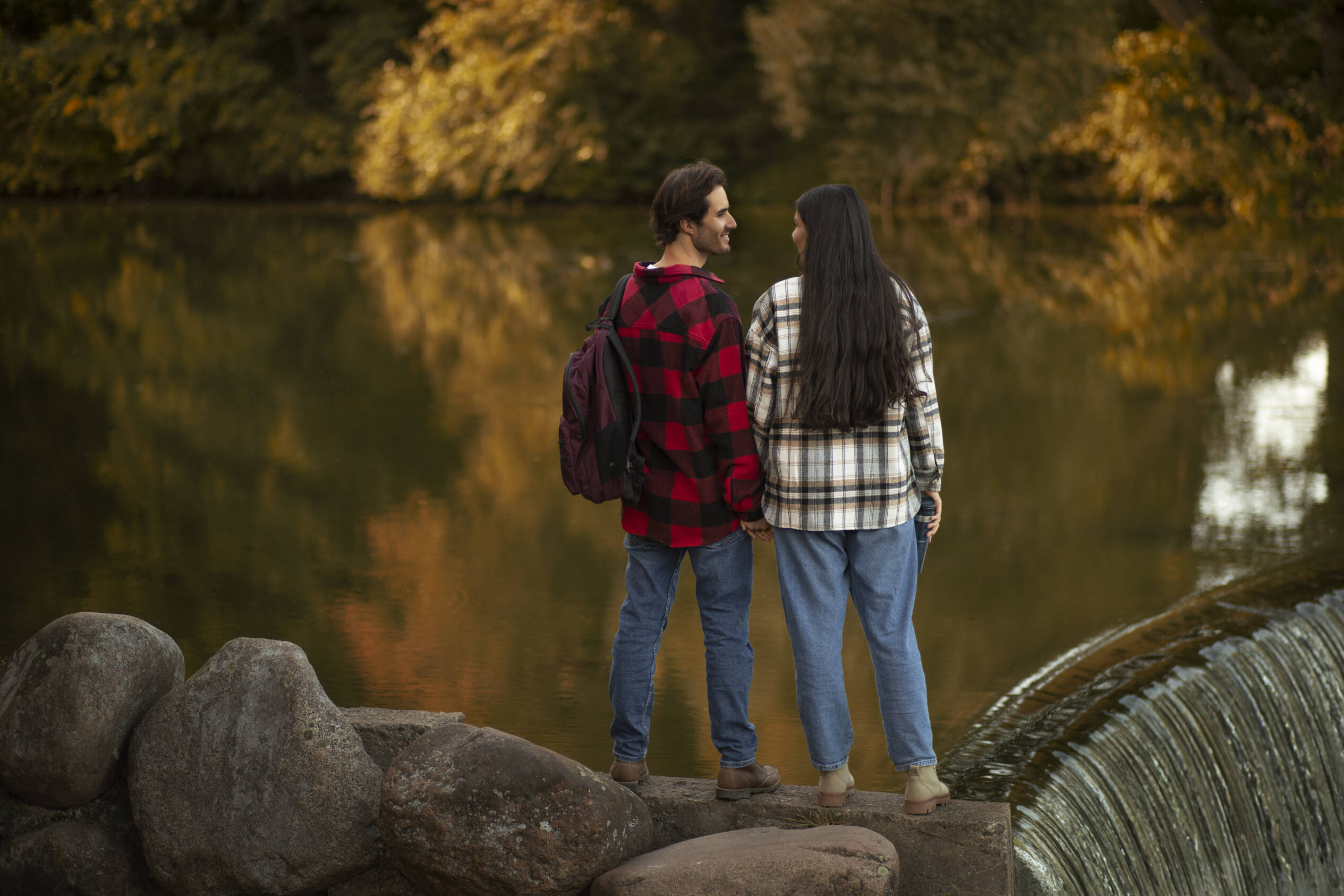 Couple hiking by a dam waterfall