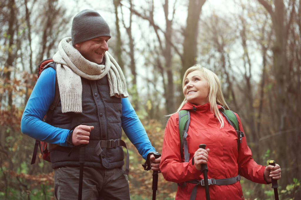 Middle aged couple hiking with hiking sticks
